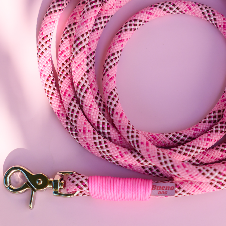 Detal smyczy Tartan Pink z różową owijką i złotym karabińczykiem na różowym tle